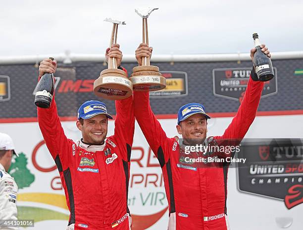 Giancarlo Fisichella, R, and Pierre Kaffer celebrate their victory in the IMSA Tudor Series GT race at Virginia International Raceway on August 24,...