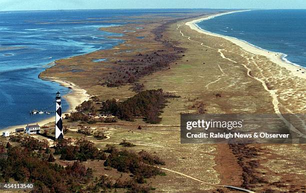 The lighthouse at Cape Lookout, N.C., so tall when viewed up close, becomes rather small when seen in this file aerial view of Core Banks. Although a...