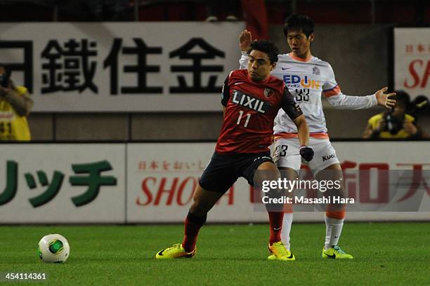 Davi of Kashima Antlers and Tsukasa Shiotani of Sanfrecce Hiroshima compete for the ball during the J.League match between Kashima Antlers and...
