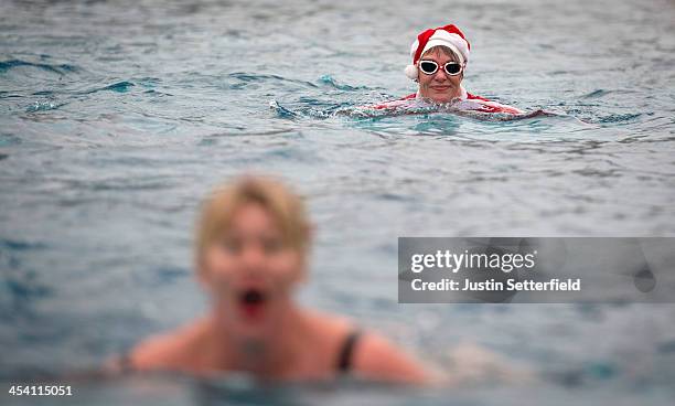 Woman dressed as Santa swims during the Outdoor Swimming Society's annual 'December Dip' at Parliament Hill Lido on December 7, 2013 in London,...