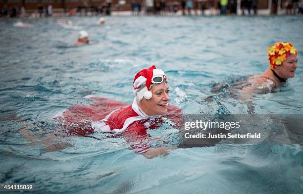 Woman dressed as Santa swims during the Outdoor Swimming Society's annual 'December Dip' at Parliament Hill Lido on December 7, 2013 in London,...