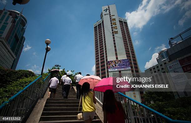 China-language-politics-Guangdong,FEATURE by Felicia SONMEZ This photo taken on August 11, 2014 shows a pedestrian walking past the headquarters of...