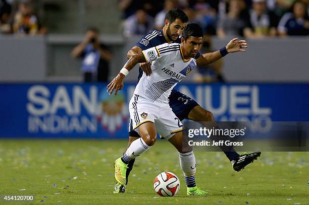 DeLaGarza of Los Angeles Galaxy is pursued by Steven Beitashour of Vancouver FC for the ball at StubHub Center on August 23, 2014 in Los Angeles,...