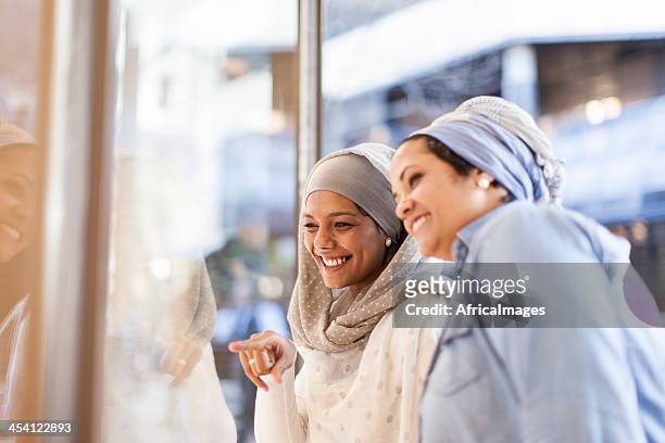 muslim friends window shopping - cape town bo kaap stock pictures, royalty-free photos & images