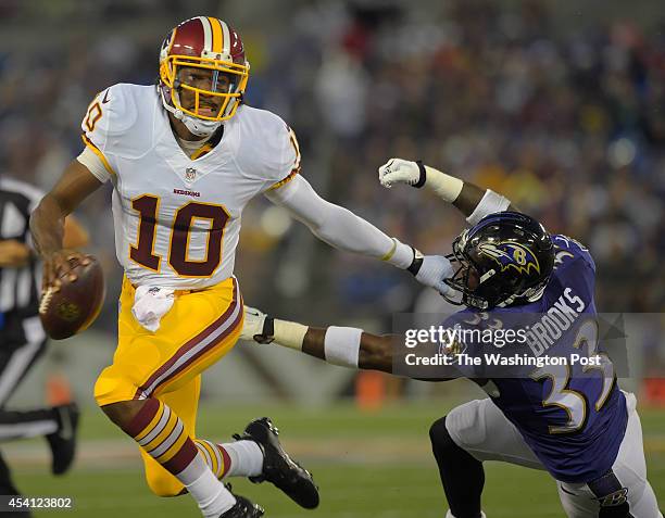 Washington quarterback Robert Griffin III , left, pushes off Baltimore free safety Terrence Brooks as he is forced out of bounds on a 3rd down play...
