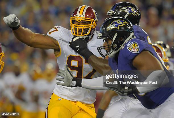 Washington defensive end Jason Hatcher , left, fights his way against the Baltimore line as the Washington Redskins play the Baltimore Ravens in a...