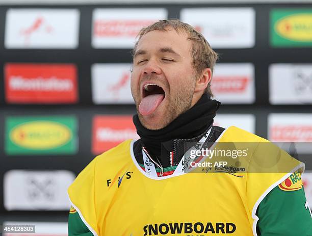 Austria's Markus Schairertry to catch snow flakes during the men's snowboard cross as part of the FIS Snowboard world cup season opening, in Schruns...