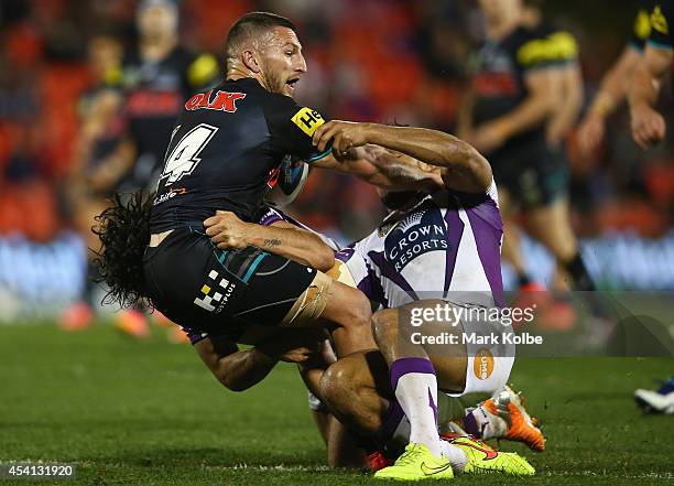 Lewis Brown of the Panthers is tackled during the round 24 NRL match between the Penrith Panthers and the Melbourne Storm at Sportingbet Stadium on...