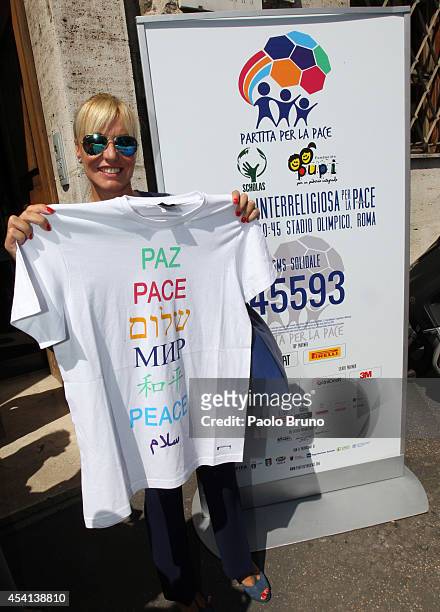 Tv Presenter Antonella Clerici holds a t-shirt with the written ' Peace' before the 'Inter-religious match for Peace' press conference on August 25,...