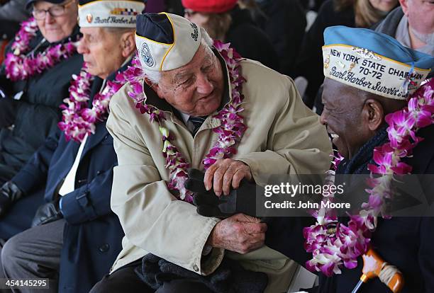 Pearl Harbor survivor Armando Galella helps fellow survivor Clark Simmons with his gloves at a ceremony marking the 72nd anniversary of the attack on...