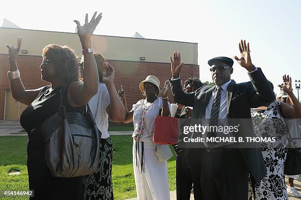 Funeral goers gestures as they enter the Friendly Temple Missionary Baptist Church for the funeral of slain 18-year old teenager Michael Brown Jr. In...