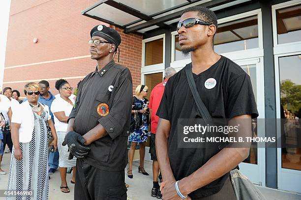 Members of the New Black Panthers stand on guard outside the Friendly Temple Missionary Baptist Church where the the funeral of slain 18-year old...