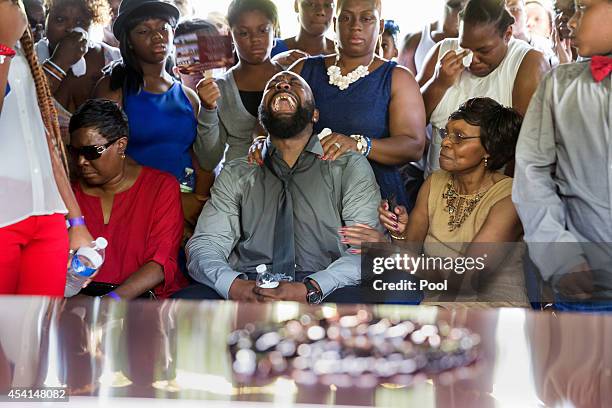 Michael Brown Sr. Yells out as the casket is lowered into the ground during the funeral for his son Michael Brown at St. Peters Cemetery on August...