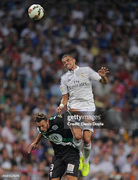 Pepe of Real Madrid CF heads the ball while being challenged by Francisco Jimenez Tejada alias Xisco of Cordoba CF during the La liga match between...