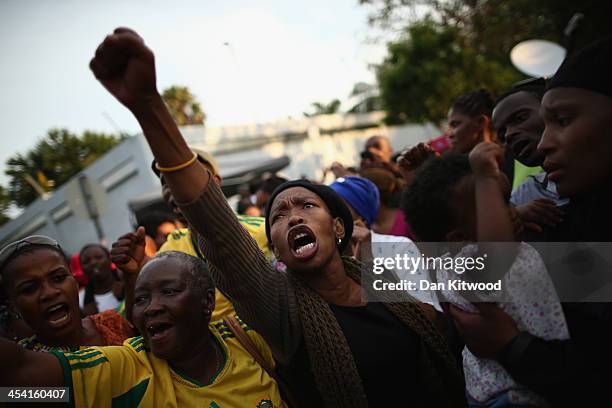 Wellwishers sing outside the Houghton home of the former South African President Nelson Mandela on December 7, 2013 in Johannesburg, South Africa....