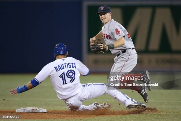 Brock Holt of the Boston Red Sox is upended in the ninth inning during MLB game action by Jose Bautista of the Toronto Blue Jays who breaks up a...