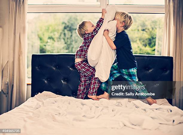 two little boys having a pillow fight - pillow fight stock pictures, royalty-free photos & images