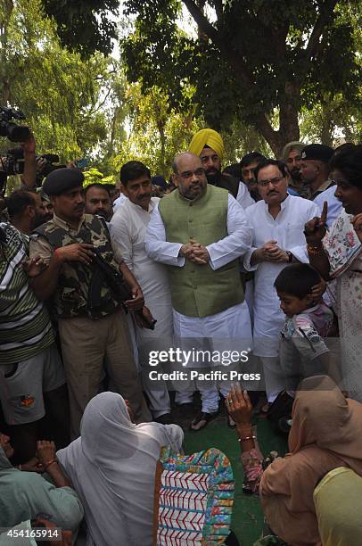 Indias Bhartiya Janta Party National President, Amit Shah talks with a group of displaced people during his visit to a camp for displaced people from...