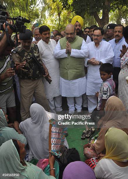 Indias Bhartiya Janta Party National President, Amit Shah talks with a group of displaced people during his visit to a camp for displaced people from...