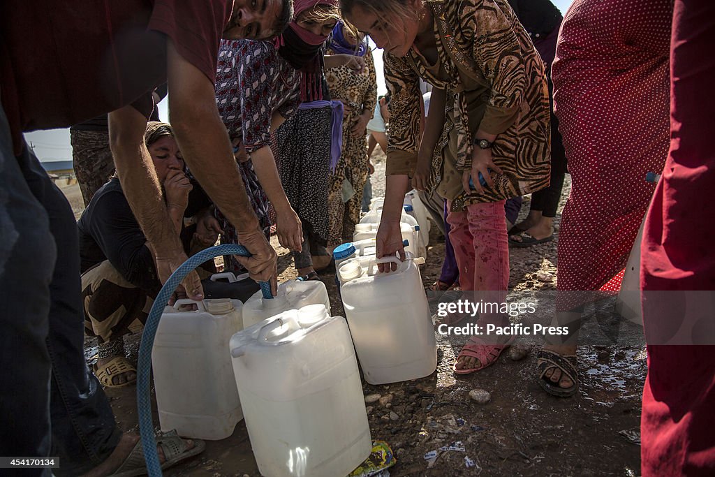 Yazidi refugees queue for water at Delal Refugee Camp in...