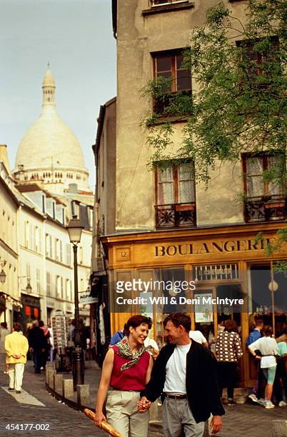 france, paris, montmartre, couple in street, sacre-coeur in distance - boulangerie paris ストックフォトと画像