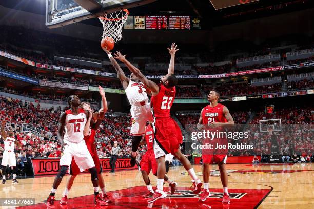 Chris Jones of the Louisville Cardinals drives to the basket against Elridge Moore of the Louisiana-Lafayette Ragin' Cajuns during the game at KFC...