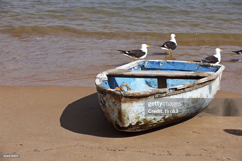 Old blue rowing boat on the beach