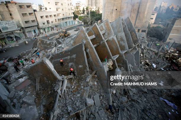 Palestinian residents inspect the remains of a building that was destroyed by an Israeli air strike in Gaza City on August 26 killing two...