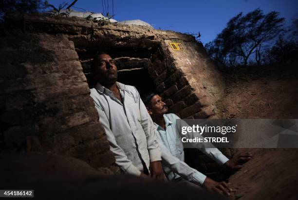 Indian villagers look out of an army bunker during alleged shooting from the Pakistan side of the Line of Control at Abdullian village, some 35 kms...