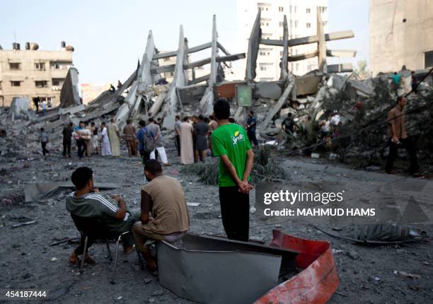 Palestinian residents inspect the remains of a building that was destroyed by an Israeli air strike in Gaza City on August 26 killing two...