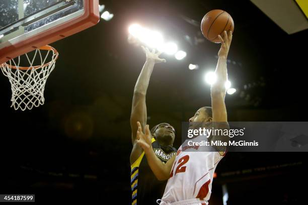 Traevon Jackson of the Wisconsin Badgers drives to the hoop with Chris Otule of the Marquette Golden Eagles defending during the second half at Kohl...