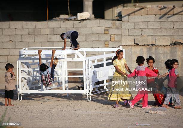 Displaced Iraqi children who fled Wadi Osaj village near Jalawla as battles between peshmerga and Islamic State jihadists broke out play as they take...