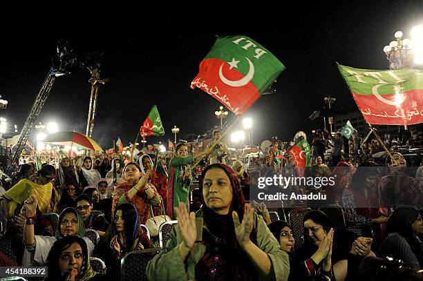 Pakistan Tehreek-i-Insaaf , supporters hold Pakistani flags and shout slogans during ongoing anti-government protests at D Square in Islamabad's Red...