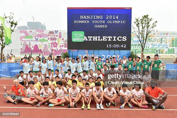 Former high jumper Kajsa Bergqvist of Sweden and World Long Jump champion Dwight Phillips of United States pose with children for a group photo...