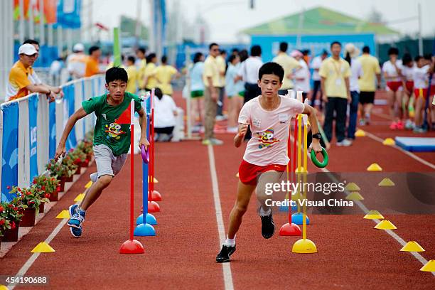 Boys run in the relay race during the IAAF Kids Athletics Program at Yanshan Road on August 26, 2014 in Nanjing, China.