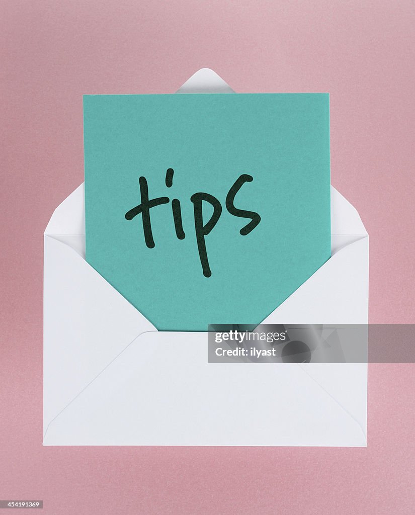 White envelope containing blue tips on pink background