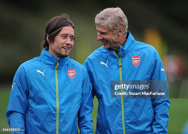 Arsenal manager Arsene Wenger with Tomas Rosicky during a training session at London Colney on August 26, 2014 in St Albans, England.