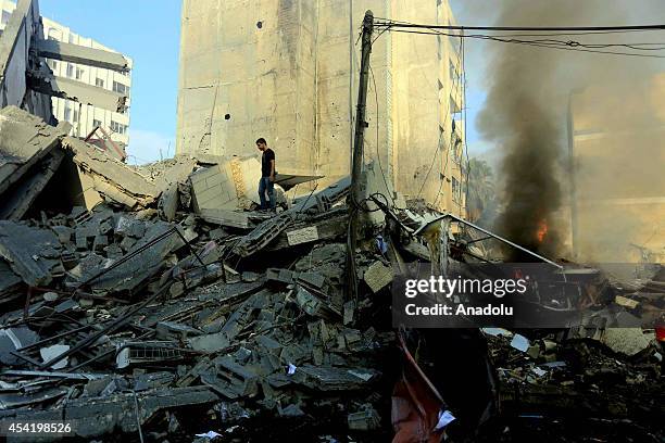 Palestinians collect usable belongings after Israel forces bomb 15-storey Basha Tower, containing apartments and offices, in Gaza City, Gaza City on...