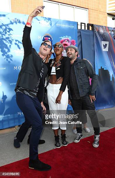 Fitz And The Tantrums band members Michael Fitzpatrick, Noelle Scaggs and James King take a selfie with Grover and Abby Cadabby at the 2014 US Open's...