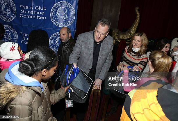 Michael Kay and Jodi Applegate hand out free bags to kids at the "Cloudy With A Chance of Meatballs 2" Holiday Screening hosted by The Friar's Club...