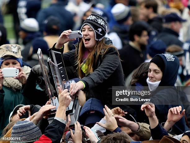 Members of the Rice University student body get their hands on the Conference USA trophy after defeating Marshall Thundering Herd at Rice Stadium on...