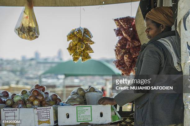 South African street vendor awaits customers in Alexandra Township on the backdrop of the Sandton Towers, one of Africa's leading and most...