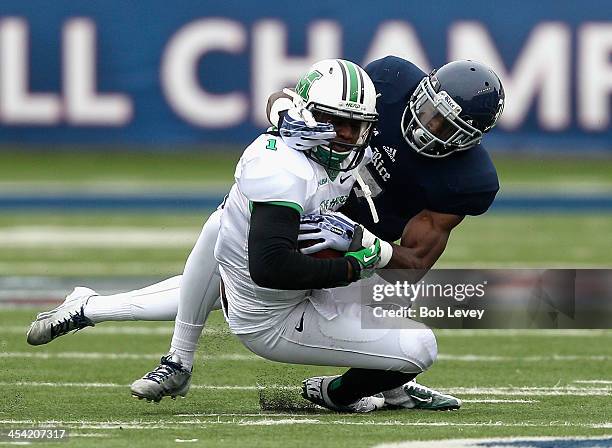 Tommy Shuler of the Marshall Thundering Herd is tackled by Julius White of the Rice Owls at Rice Stadium on December 7, 2013 in Houston, Texas.