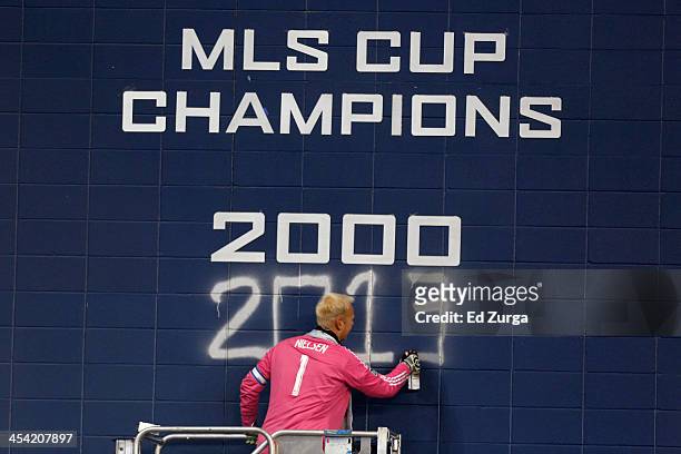 Jimmy Nielsen of Sporting Kansas City spray paints 2013 on the wall after they won the MLS Cup Final against Real Salt Lake at Sporting Park on...
