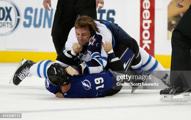 Mark Stuart of the Winnipeg Jets fights B.J. Crombeen of the Tampa Bay Lightning during the first period at Tampa Bay Times Forum on December 7, 2013...