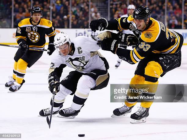 Sidney Crosby of the Pittsburgh Penguins carries the puck in front of a stickless Zdeno Chara of the Boston Bruins in the second period during the...