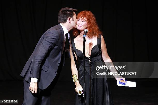 French actress and president of the jury Sabine Azema is kissed by Angouleme's mayor Xavier Bonnefont on August 26, 2014 in Angouleme during the...