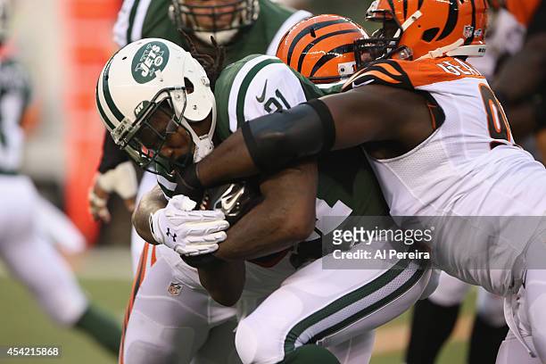 Running Back Chris Johnson of the New York Jets is stopped by Defensive End Robert Geathers of the Cincinnati Bengals at Paul Brown Stadium on August...