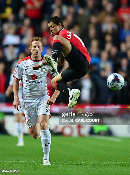 Manchester United's Mexican striker Javier Hernandez vies with MK Dons English defender Dean Lewington during the English League Cup second round...