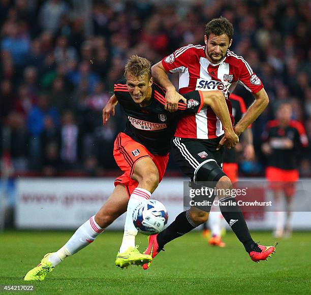 Nick Proschwitz of Brentford looks to get past Fulham's Dan Burn during the Capital One Cup Second Round match between Brentford and Fulham at...